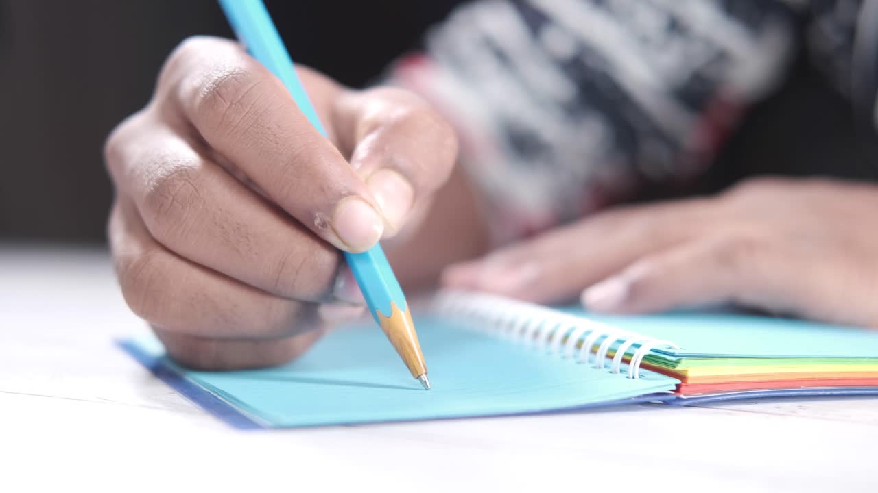 persona que escribe en un cuaderno