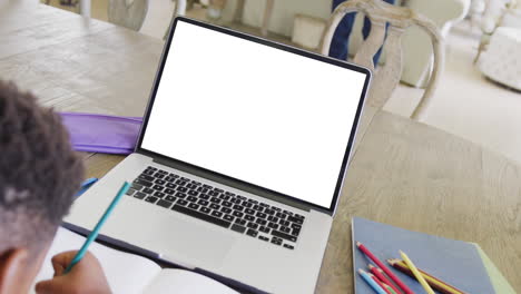 composición de un niño afroamericano en una computadora portátil aprendiendo en línea con pantalla en blanco