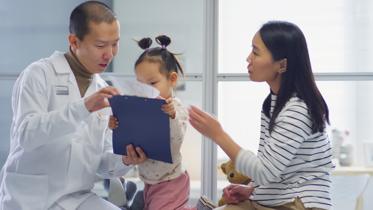 Asian Mother and Daughter on Consultation with Pediatrician