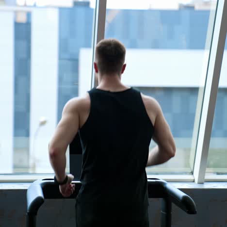 man running on treadmill machine. young athletic man exercising and running on treadmill in sport gym