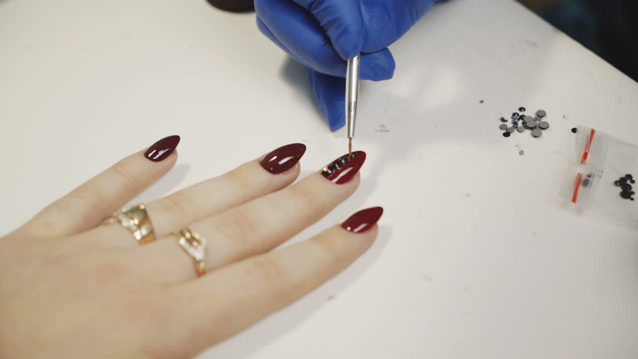 Woman getting her nails decorated at a nail salon