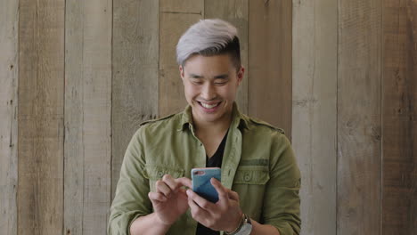 portrait-of-young-handsome-asian-man-texting-browsing-online-using-smartphone-social-media-app-smilign-enjoying-mobile-communication