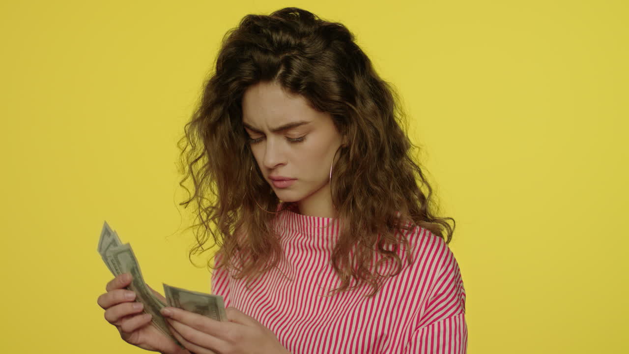 una mujer molesta contando dinero en efectivo.