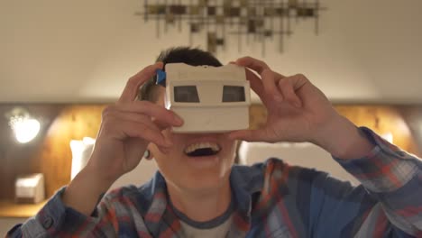 an adult having fun playing with a model g view-master viewer from the last years of the sawyer's toy manufacturing era in a vintage-style motel room