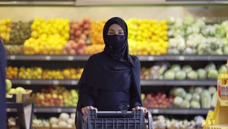 woman in hijab doing grocery shopping in supermarket, wearing mask