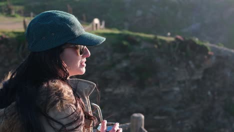 woman drinking yerba mate, typical argentine drink, on the beach, while watching the sunset pichilemu, punta de lobos, beach for surfing, chile