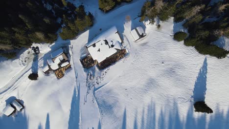 Aerial:-Birds-Eye-view-with-rotating-motion-of-a-ski-hut-surrounded-by-a-slope-in-Davos,-Switzerland