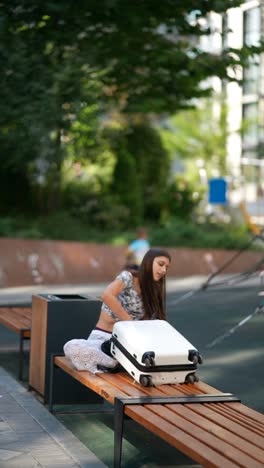 woman packing a suitcase in a city park