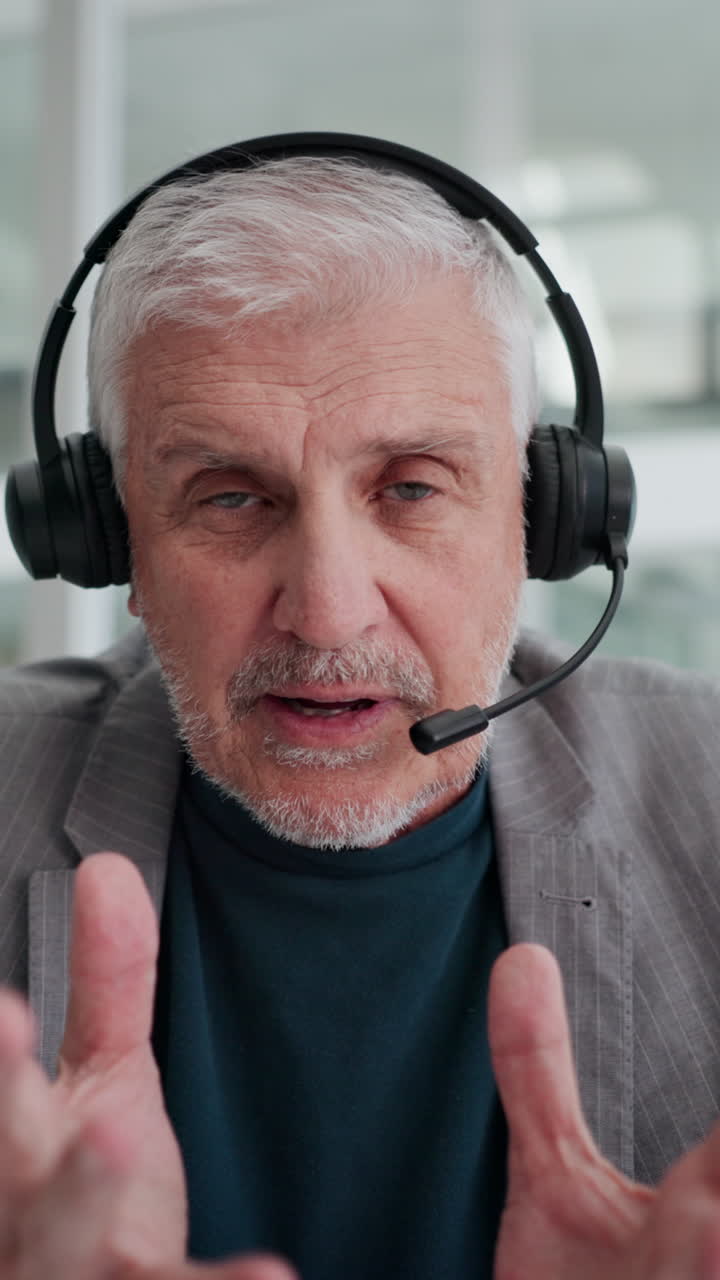 Anziano con auricolari che parla durante una videochiamata.