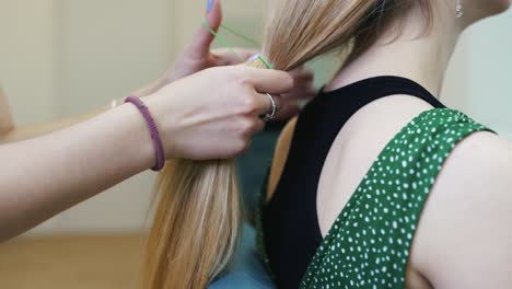 haciendo trenzas de cabello largo y rubio