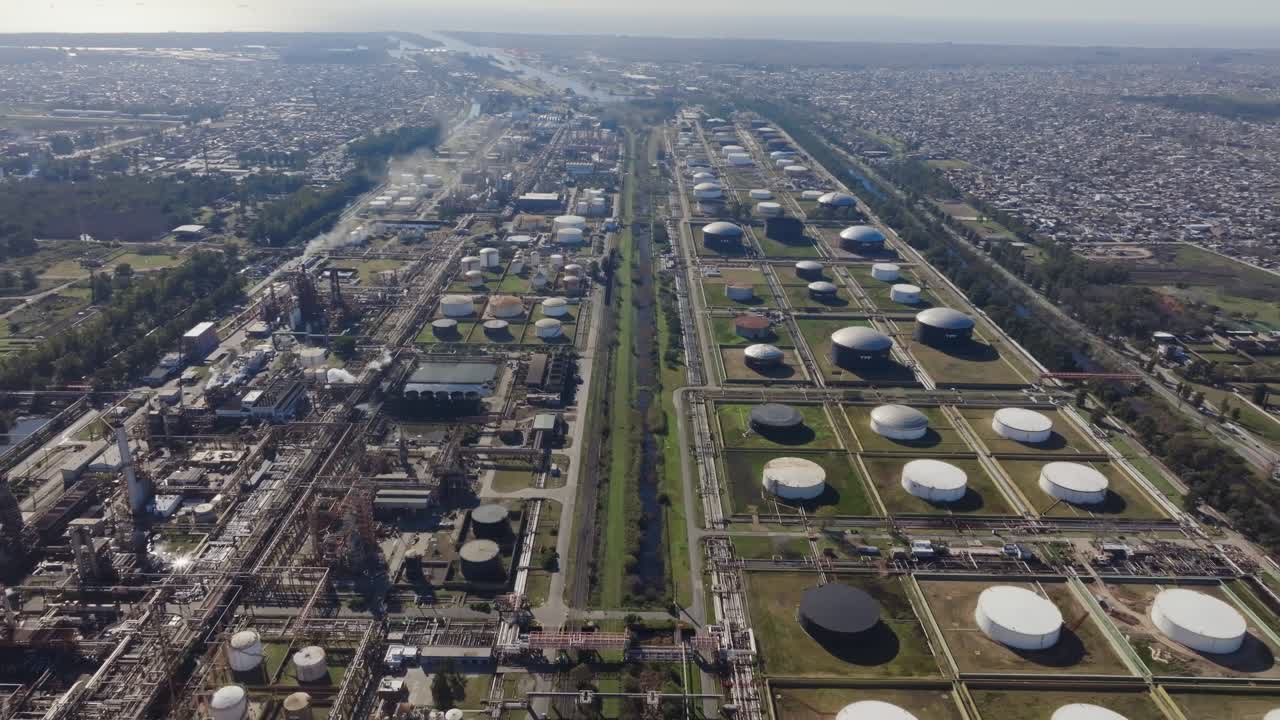 Daytime drone shot of oil refinery and natural gas facility near neighborhood