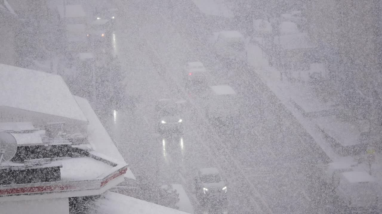 Heavy Snowfall on an Urban Street with Cars