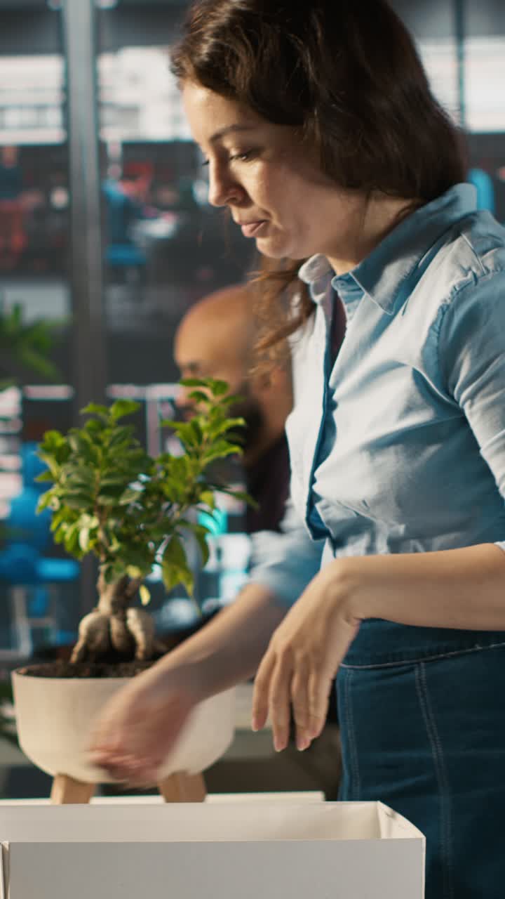 Video vertical: Trabajador molesto en la oficina empacando plantas de escritorio en su último día de trabajo