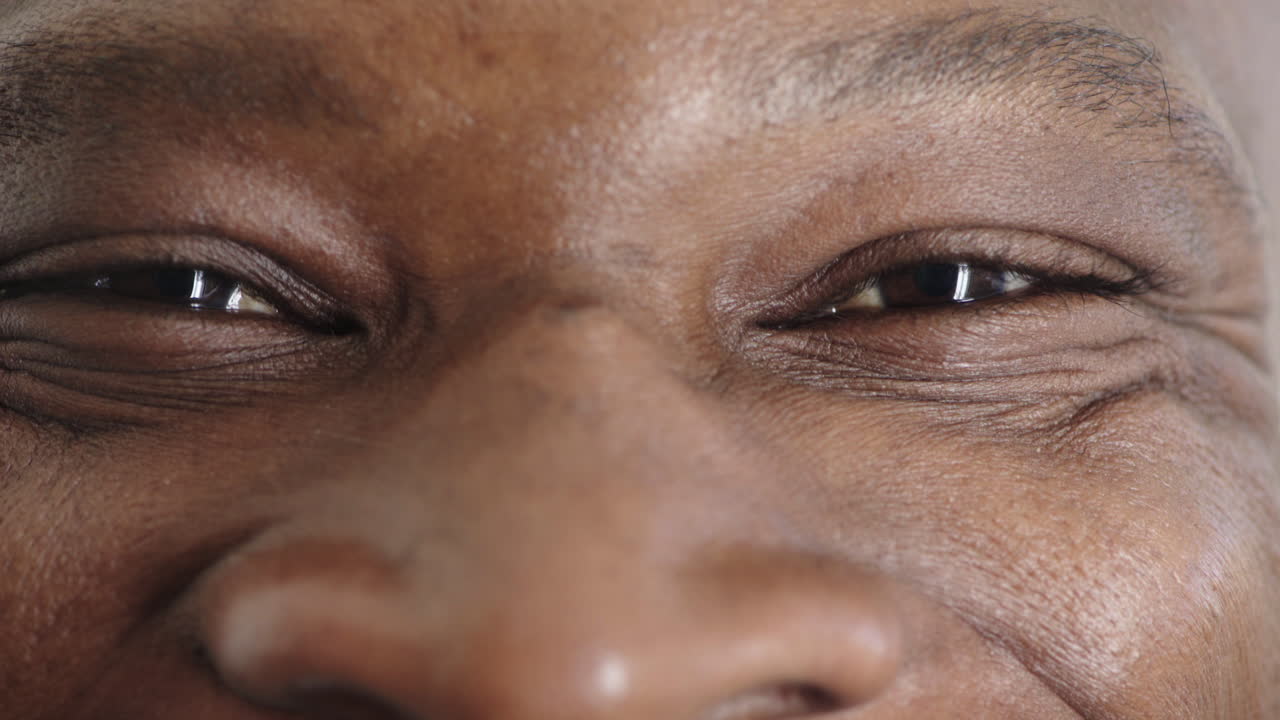 close-up de homem afro-americano olhos olhando satisfação feliz no reflexo da câmera conceito de visão saudável