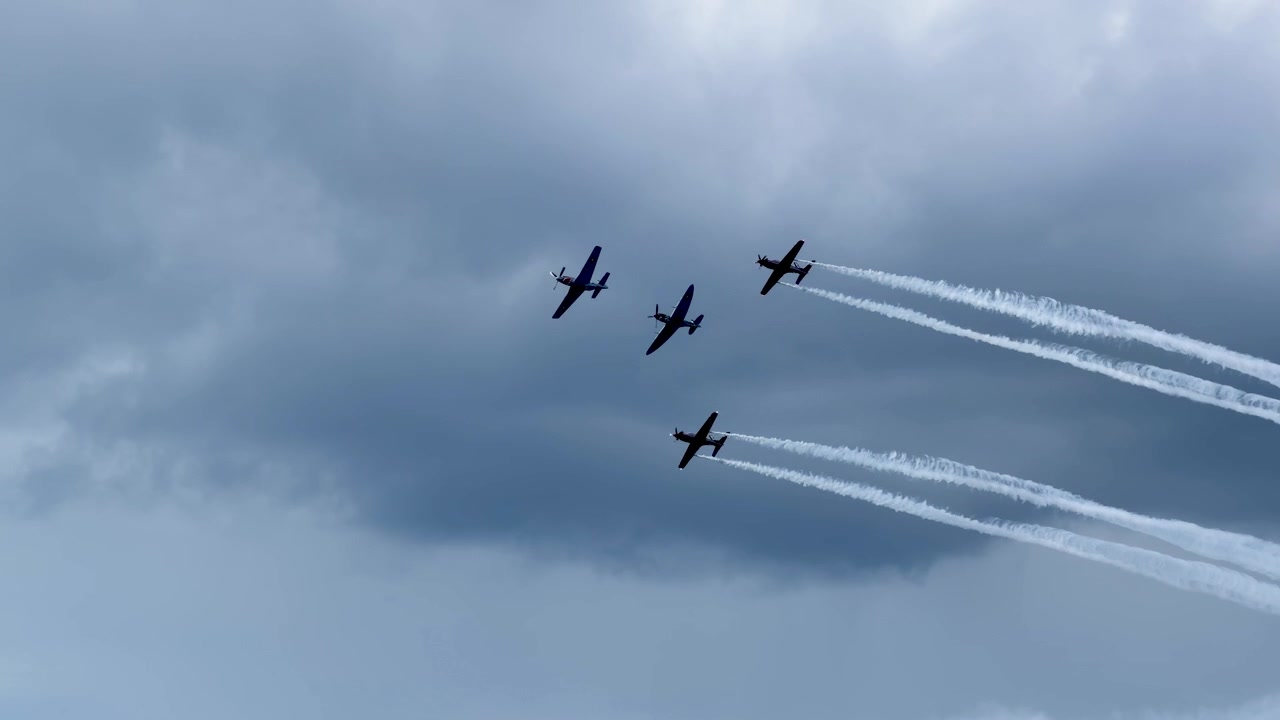 Aerei a elica eseguono un volo in formazione con scie di fumo bianco contro un cielo nuvoloso in Australia
