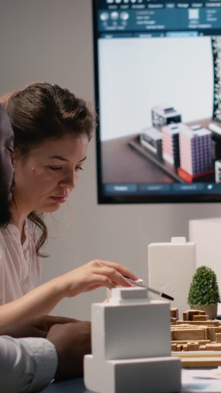 Vertical Video Real estate professionals engage in meeting to review blueprints and 3D models