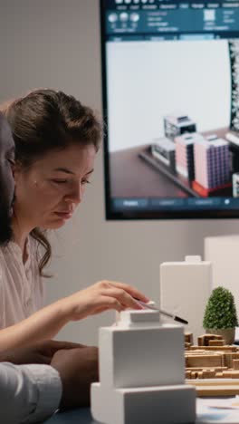 vertical video real estate professionals engage in meeting to review blueprints and 3d models