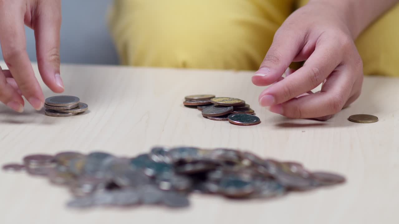 Una persona conta meticolosamente le monete a casa, mostrando un momento di concentrazione finanziaria.