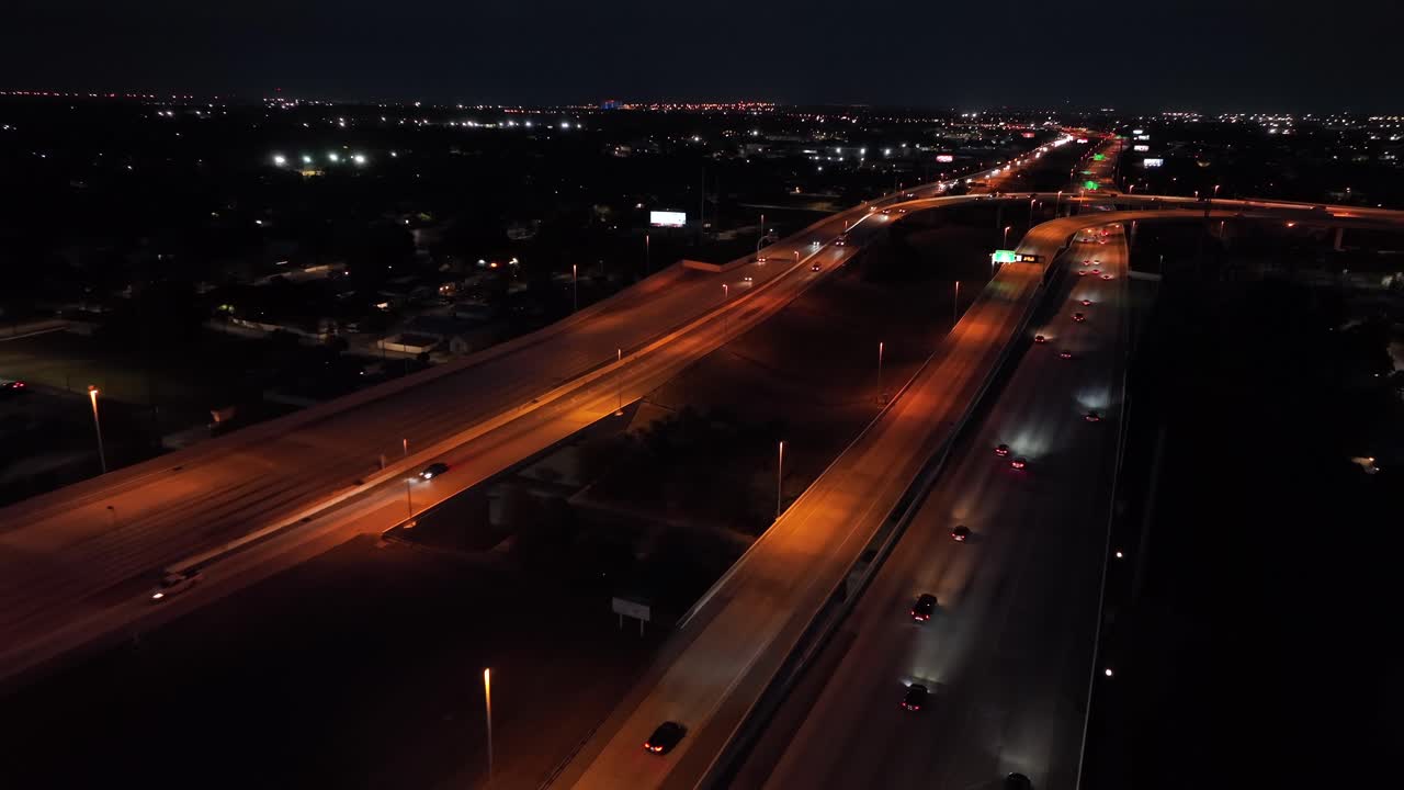 Orange illuminated interstate highway in Florida with busy traffic at night. Aerial flyover tracking shot. Many cars speeding on road at midnight. Tampa, Florida