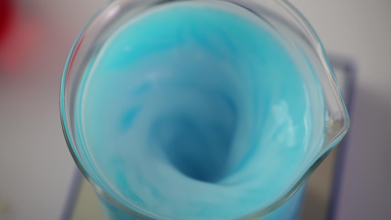 Blue liquid swirling in a beaker