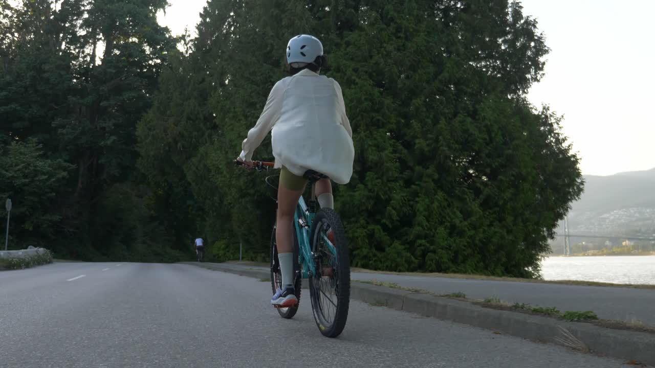 캐나다 밴쿠버 의 버라드 인 을 따라 도로 에서 자전거 를 타는 여자 를 따라