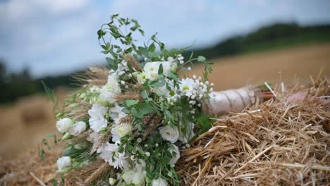 un ramo de novia blanco en un fardo de heno se balancea en el viento