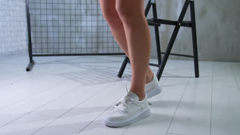 woman's legs and white sneakers