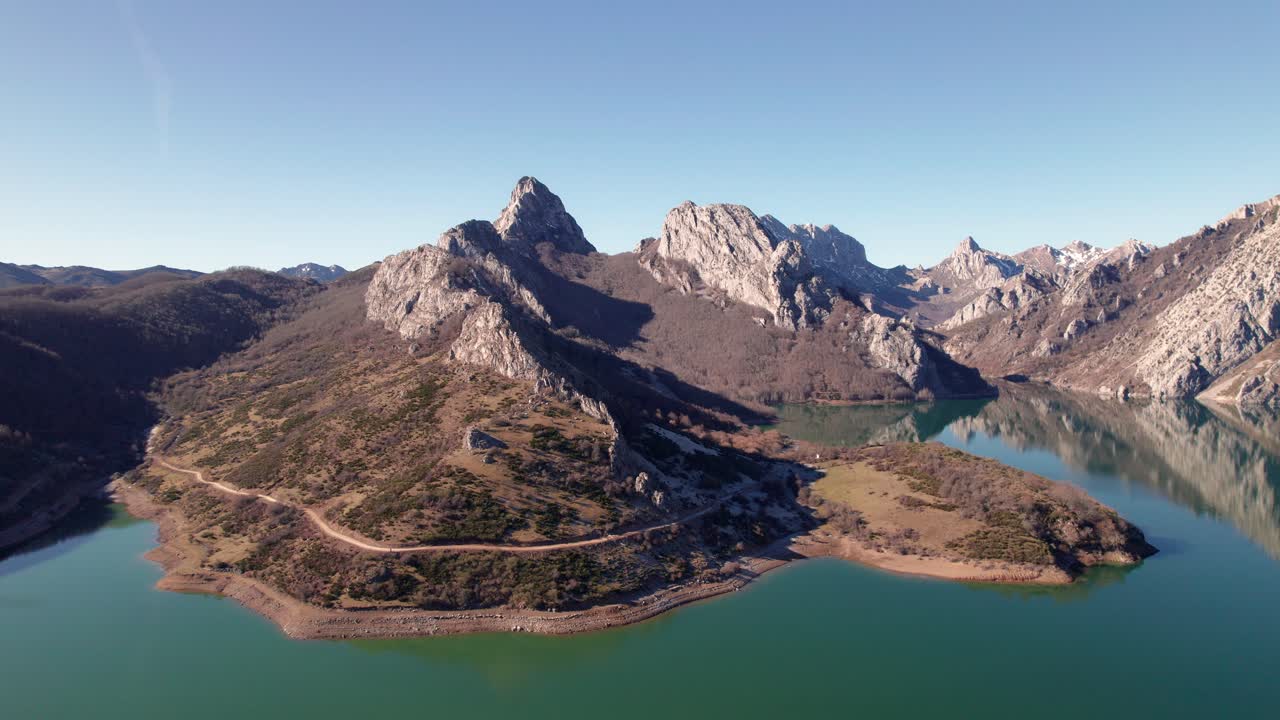 afilada, alta cordillera bext a un lago de agua verdosa en león, españa