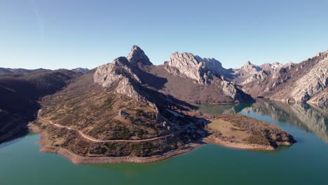 Sharp,-tall-mountain-range-bext-to-a-greenish-water-lake-in-León,-Spain