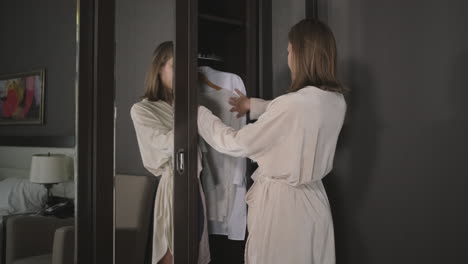 woman choosing clothes in a hotel closet