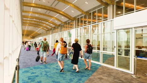 people moving through airport terminal corridor