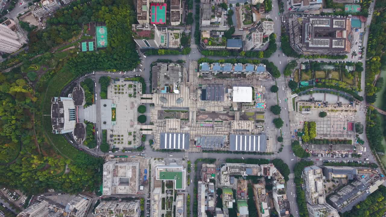 Top-down aerial view of Wuxi city showcasing dense urban blocks, intersecting streets, green park areas, and varied architecture. China, UHD