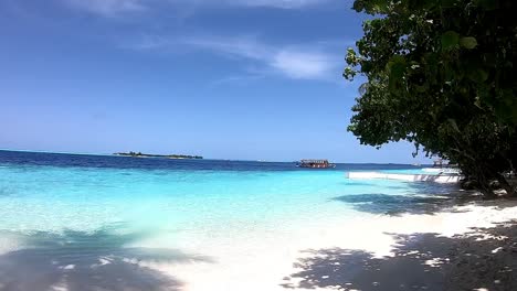 boat passing by a tropical island beach