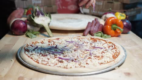 A-skilled-chef's-hand-takes-a-handful-of-onions-from-the-metal-tray