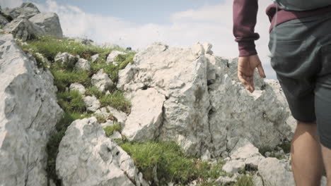 Cámara-Siguiendo-A-Un-Excursionista-Desde-Atrás-Subiendo-Una-Colina-En-Su-Viaje-Hacia-La-Cima-De-Muntain-Rombon