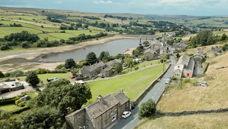 Aerial-footage-of-a-rural-industrial-village-with-old-mill-and-chimney-stack-surrounded-by-fields-1