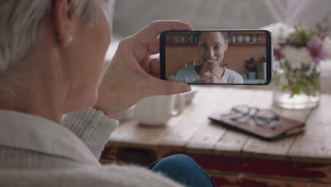 Reife-Frau,-Die-Per-Smartphone-Einen-Video-Chat-Führt-Und-Mit-Ihrer-Tochter-Auf-Dem-Handy-Bildschirm-Chattet,-Lächelt-Und-Genießt-Das-Gespräch-Und-Teilt-Ihren-Lebensstil-Mit-Der-Familie-In-4K