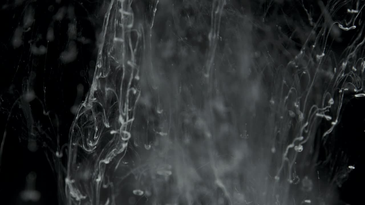 efecto de tinta blanca en agua filmado sobre fondo negro