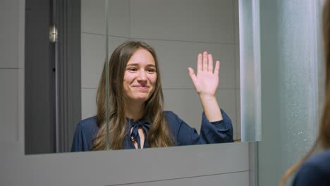 Woman-acting-and-giving-high-five-against-mirror-in-domestic-environment