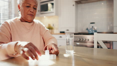 old woman with pills in kitchen