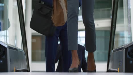 business people on an escalator in a modern building