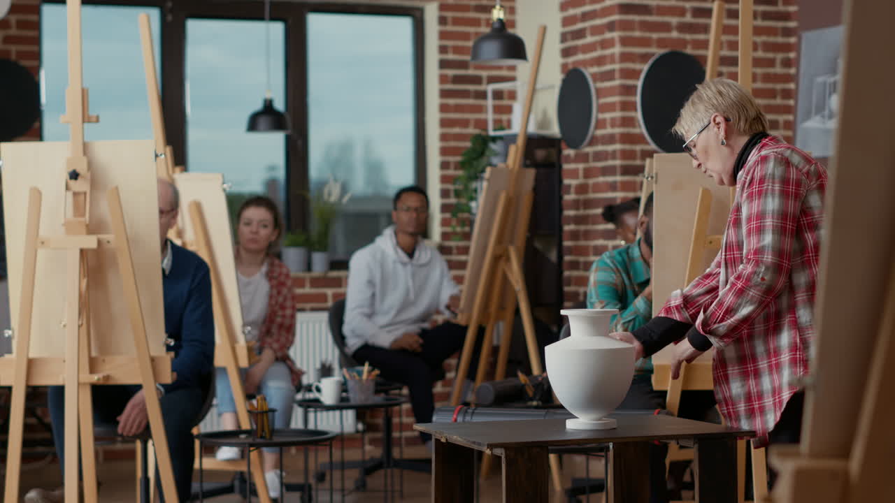 Senior teacher using vase design inspiration for people to draw
