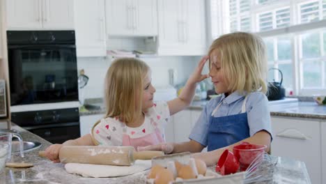 siblings making christmas cookies at home