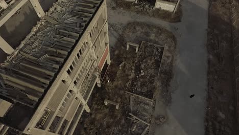 rotating aerial shot of an abandoned destroyed building beside empty street in prague during daytime