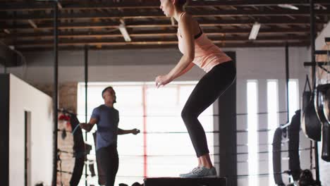 video de una mujer caucásica en forma saltando en un bloque en el gimnasio