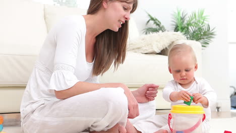 Baby-playing-with-a-red-and-green-dice-