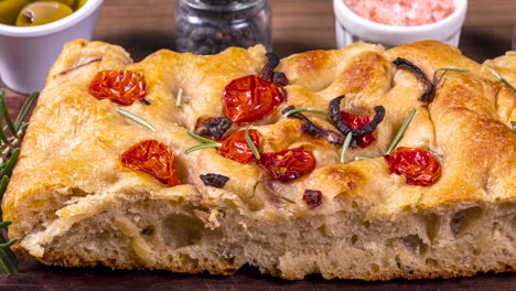 traditional italian focaccia with pepperoni, cherry tomatoes, black olives, rosemary ando onion - homemade flat bread focaccia