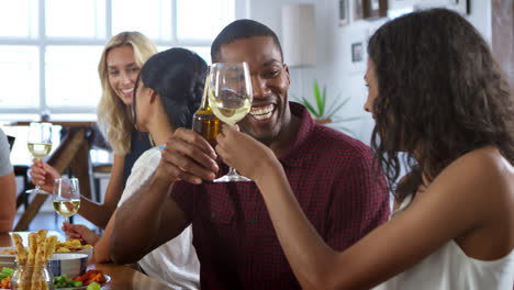 Grupo-De-Amigos-Disfrutando-Juntos-De-Una-Cena-En-Casa