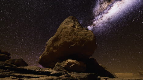 rock formation under starry sky at night in remote location