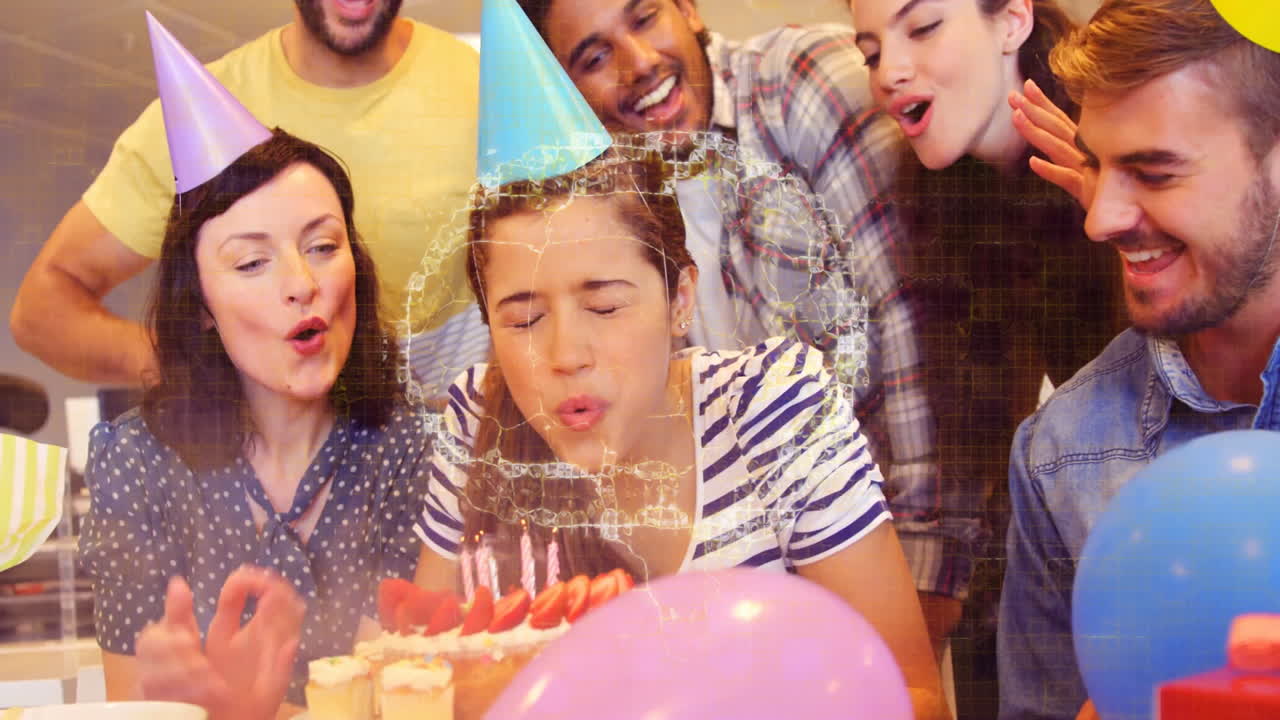 Group celebrating birthday with cake and candles, digital animation overlaying scene